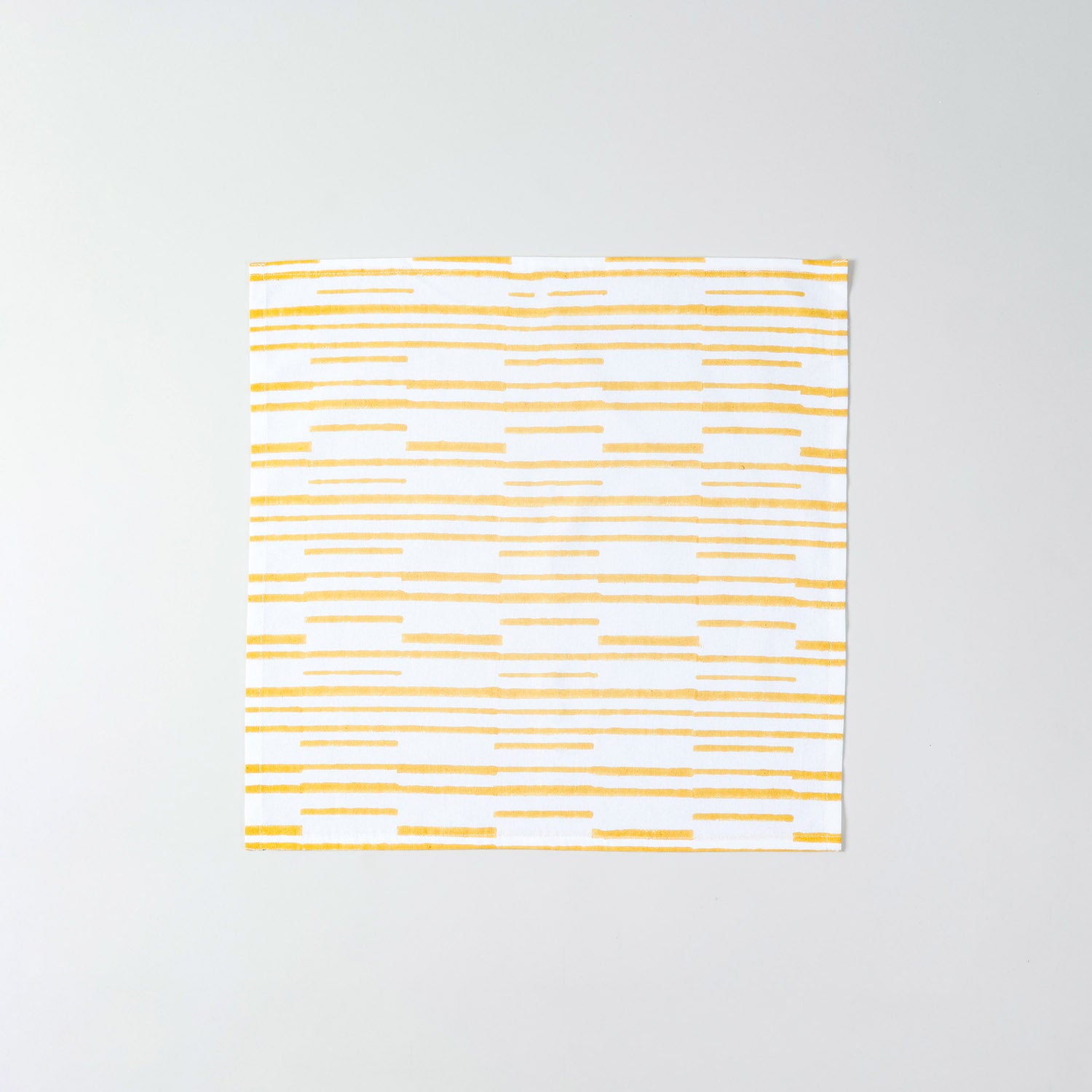 Single cotton cloth napkin featuring yellow stripe design on a crisp white background