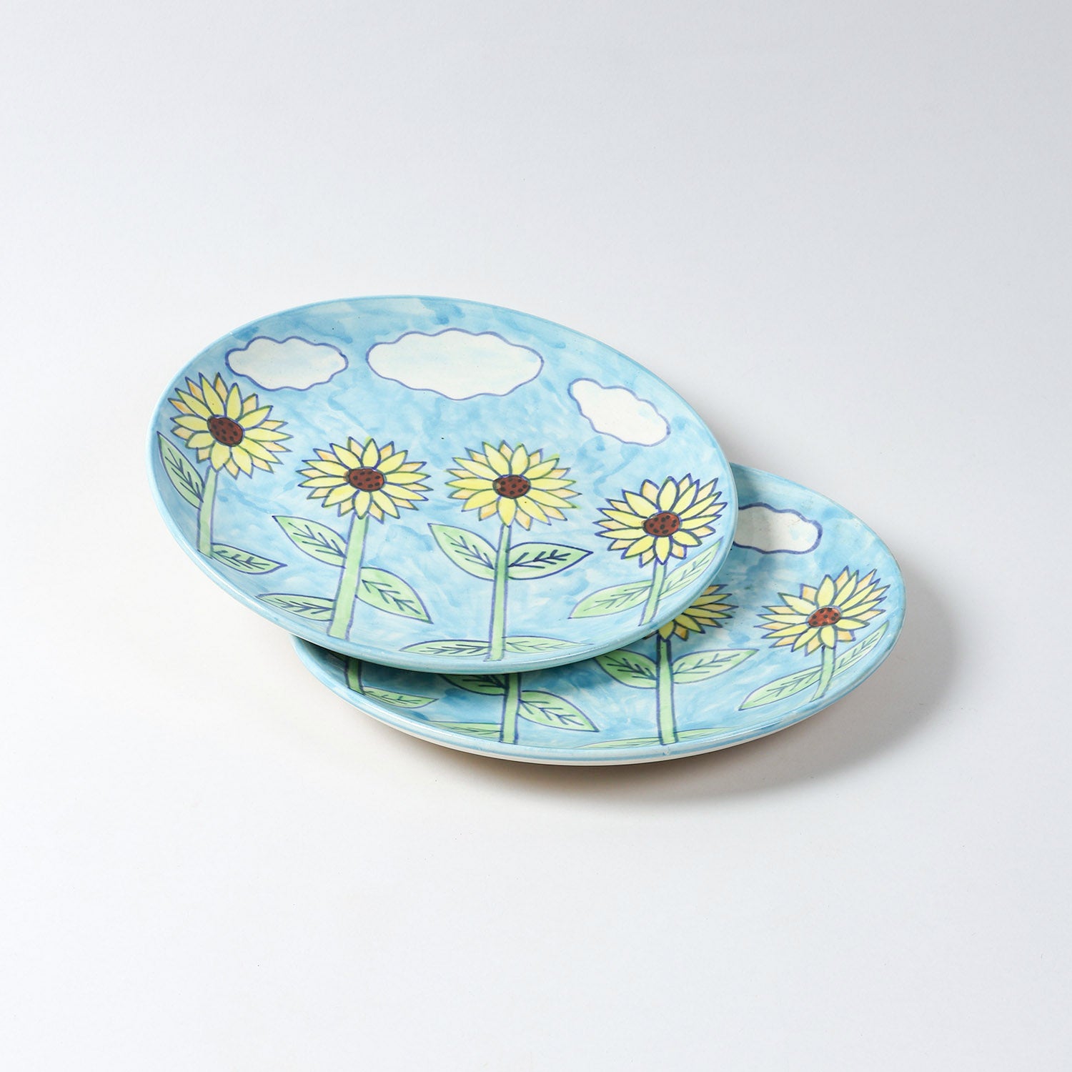 Set of 2 hand-painted Sunflower ceramic dinner plates with floral artwork and blue background, displayed on a plain background