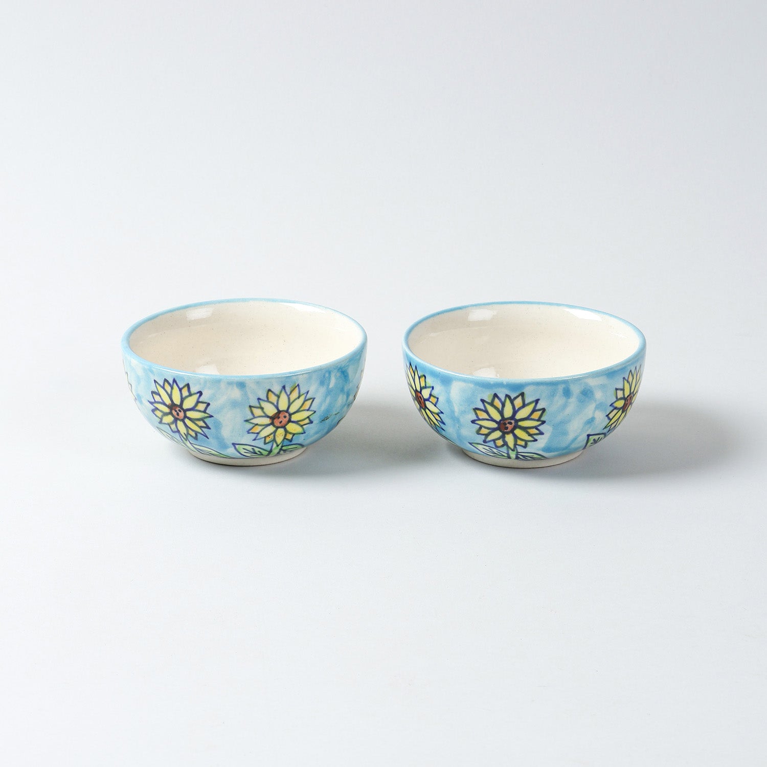  Hand-painted Sunflower ceramic katori set of 2 placed side by side on a plain background, featuring blue, yellow, and brown floral artwork from Khurja ceramics