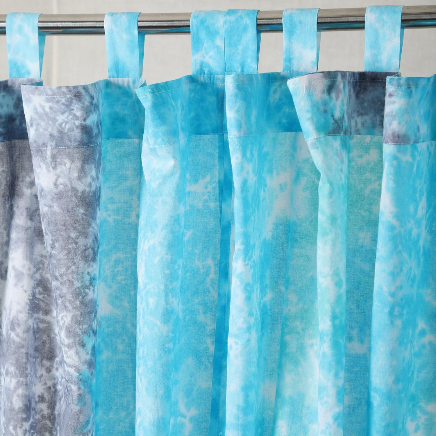 Close-up of the tab top loops on a grey and blue tie-dye mulmul cotton curtain.