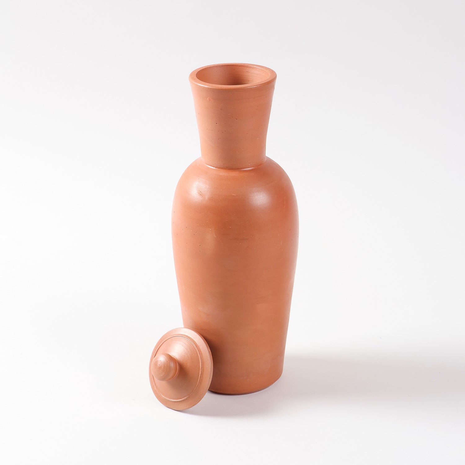 Terracotta water bottle with matching clay lid displayed open on a plain background, showcasing its handcrafted earthen design