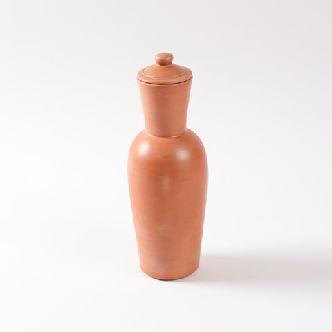 Handmade 1 litre terracotta water bottle with matching clay lid on a white background, designed for naturally cooling water