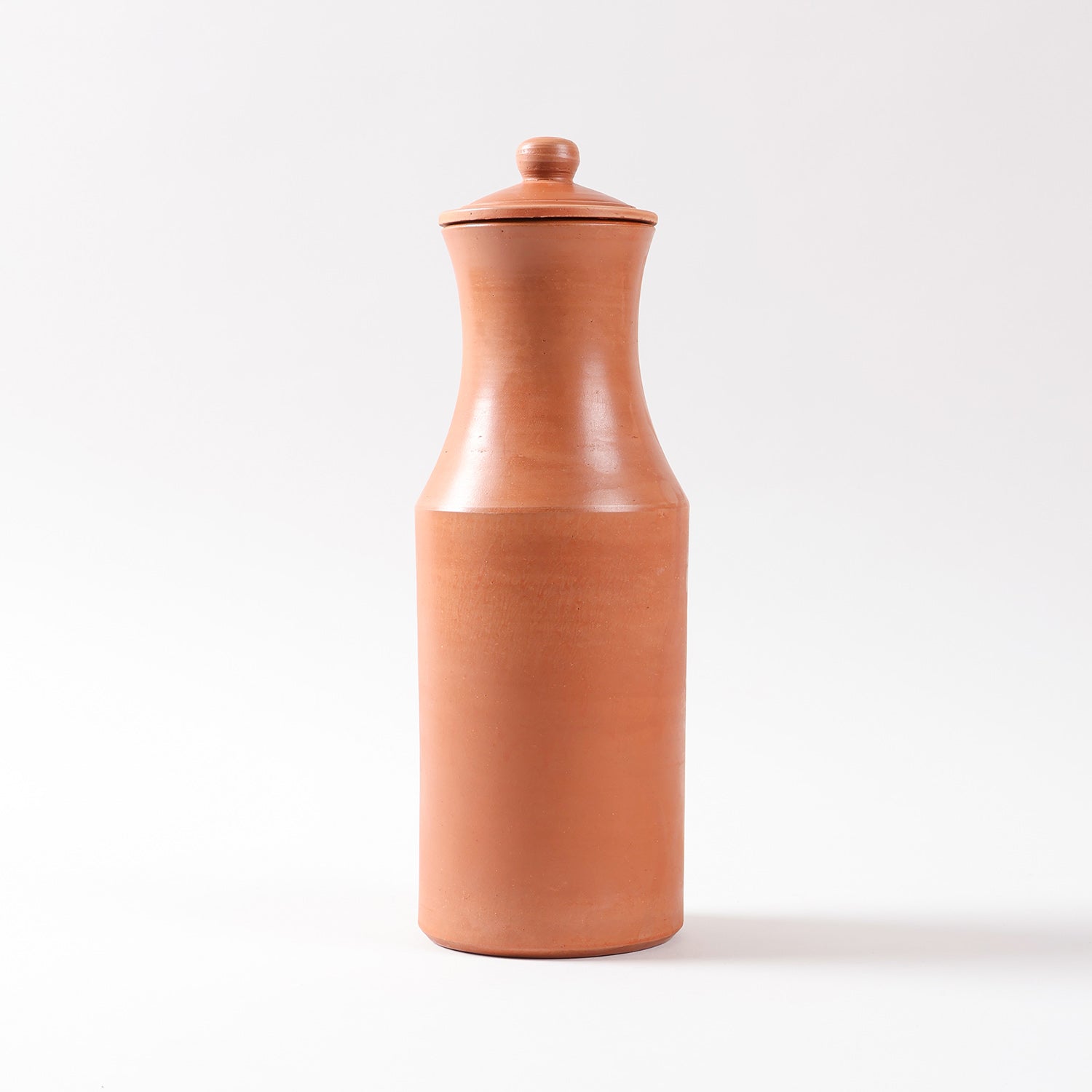 Front view of a terracotta water carafe and lid highlighting the natural clay finish and handcrafted earthen design