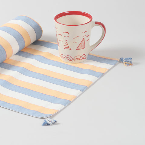 Handwoven striped cotton table runner with tassels displayed as a colourful handmade home décor accent