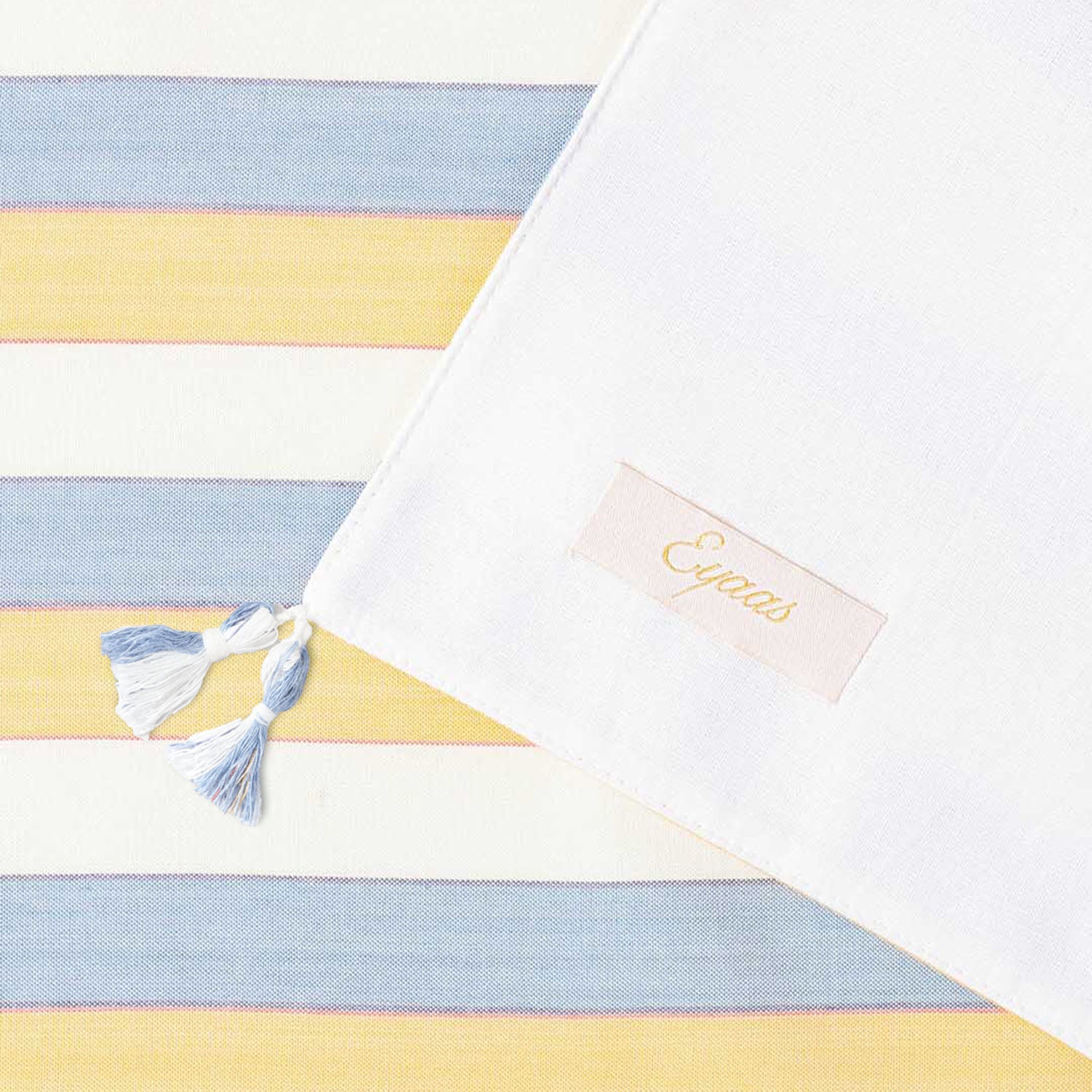 Back and front view of soft tassels and a woven striped pattern on a handcrafted cotton table runner