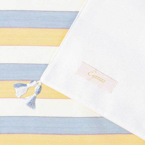 Back and front view of soft tassels and a woven striped pattern on a handcrafted cotton table runner