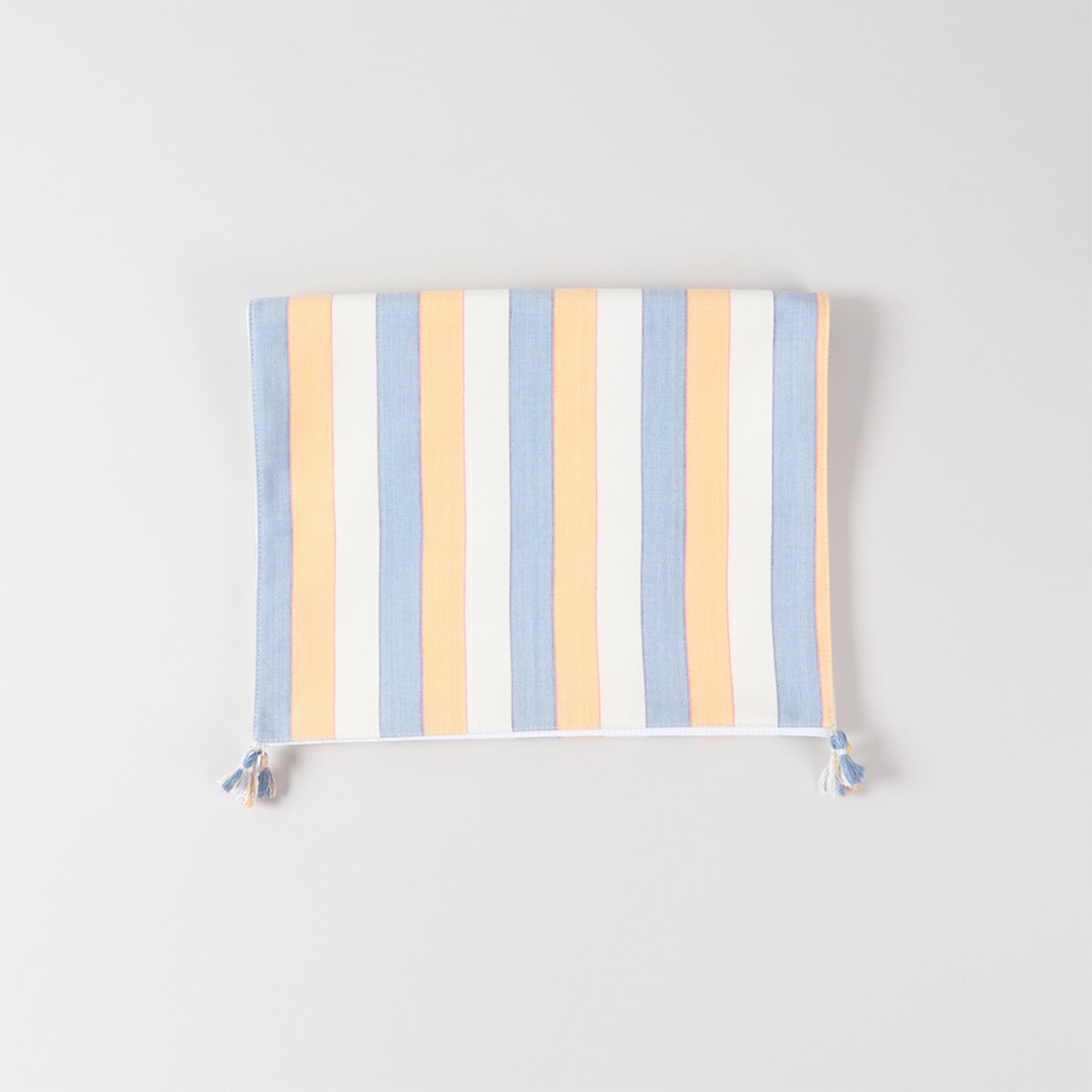 Folded handwoven cotton table runner highlighting striped design, tasselled edges, and handcrafted table linen quality