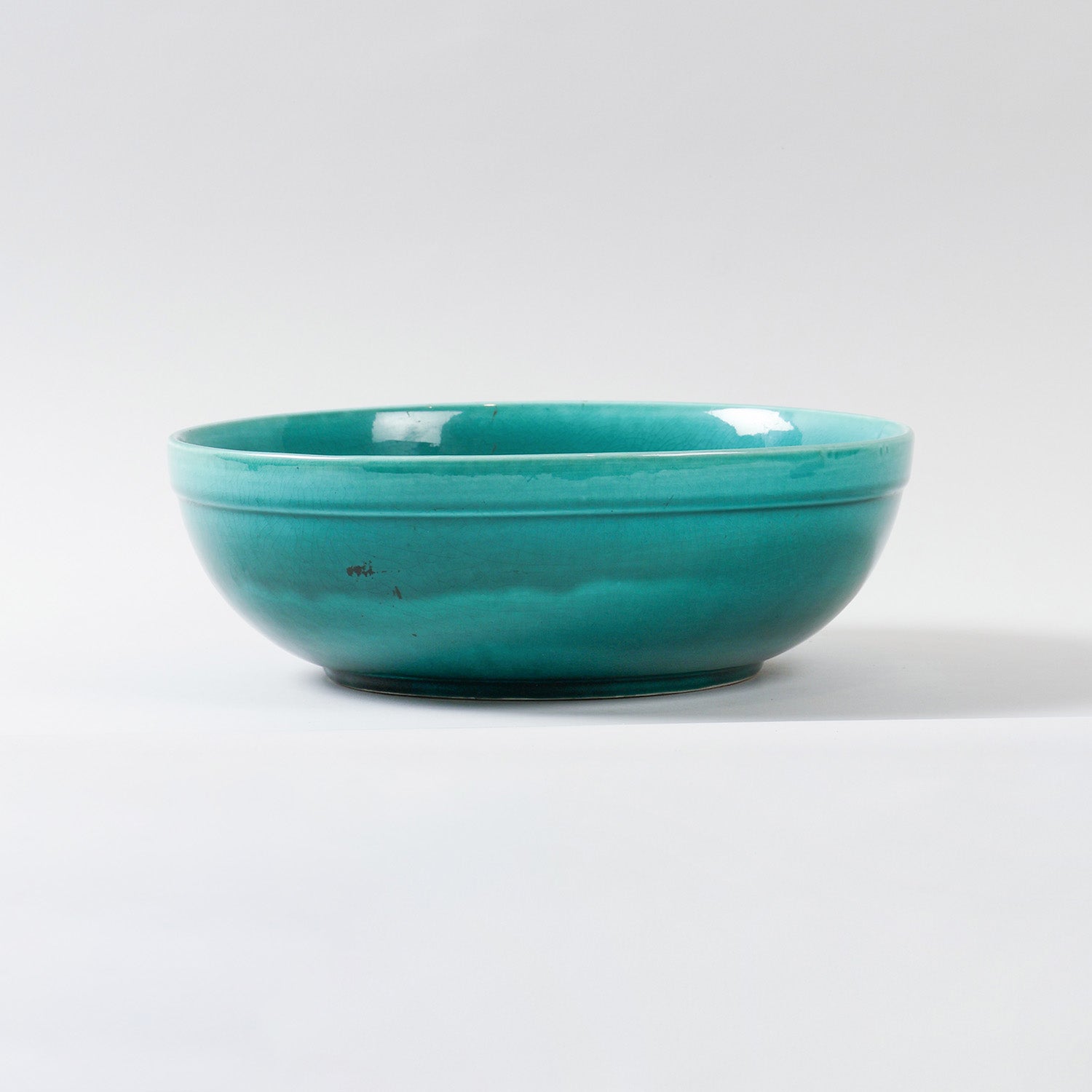 Eye-level view of a handmade turquoise ceramic bowl showcasing its glossy finish, spacious design, and handcrafted pottery details