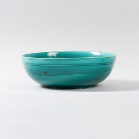 Eye-level view of a handmade turquoise ceramic bowl showcasing its glossy finish, spacious design, and handcrafted pottery details