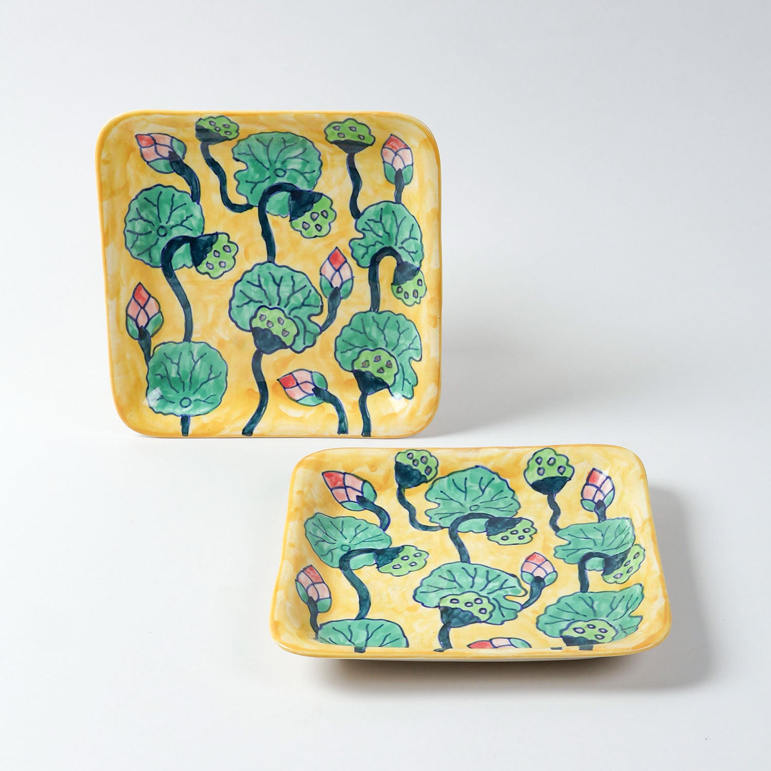 Handmade ceramic serving platters with water lily motifs on a yellow base, showcasing traditional Khurja ceramic craftsmanship and tableware design