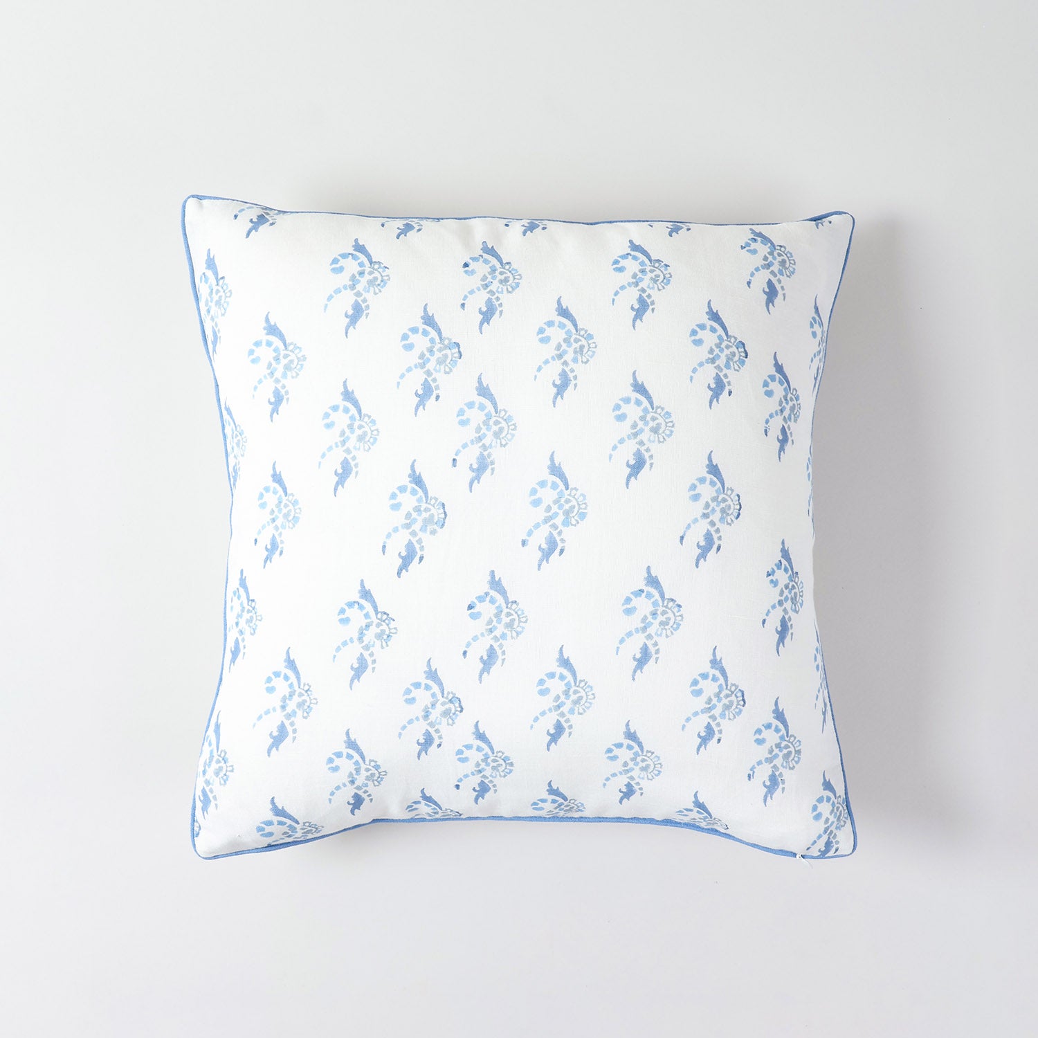 Decorative cotton linen pillow cover featuring blue swirl artwork and elegant piped border
