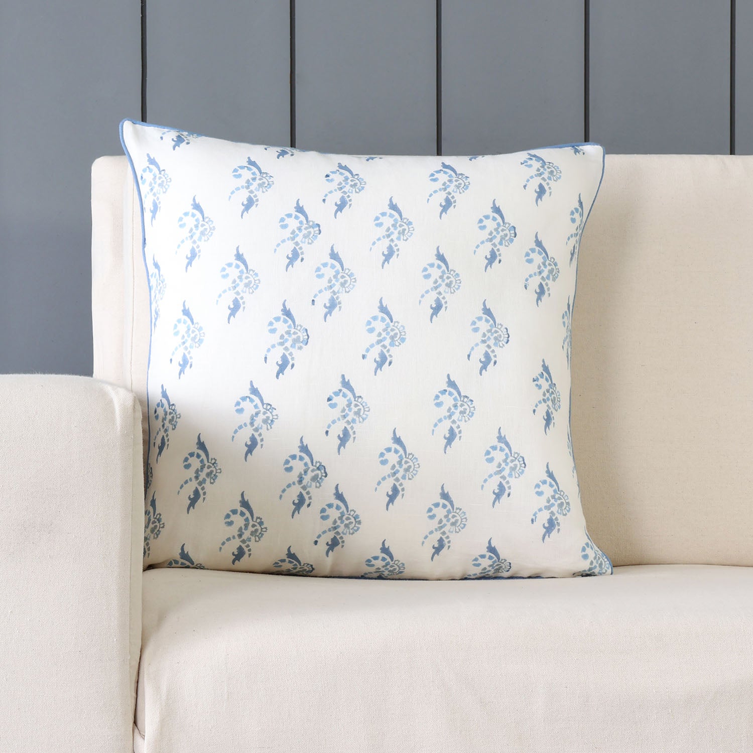 White and blue swirl-patterned cushion cover of 16x16  inches styled on a modern living room sofa.