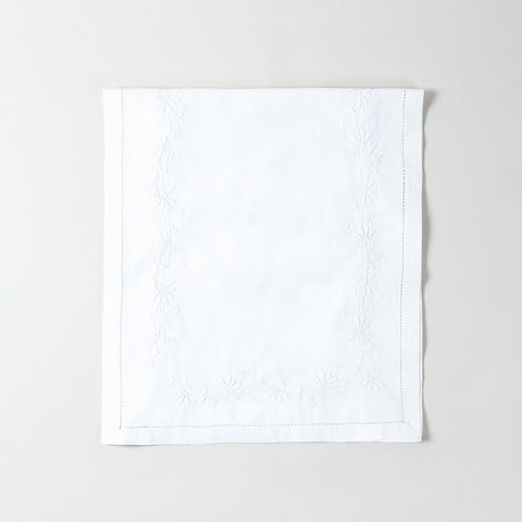 Folded white cotton table runner showcasing delicate white daisy embroidery and handcrafted Bengal chikankari detailing