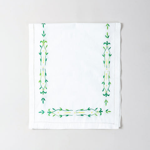  Folded Bengal chikankari runner showcasing green floral vine embroidery on soft white cotton table linen