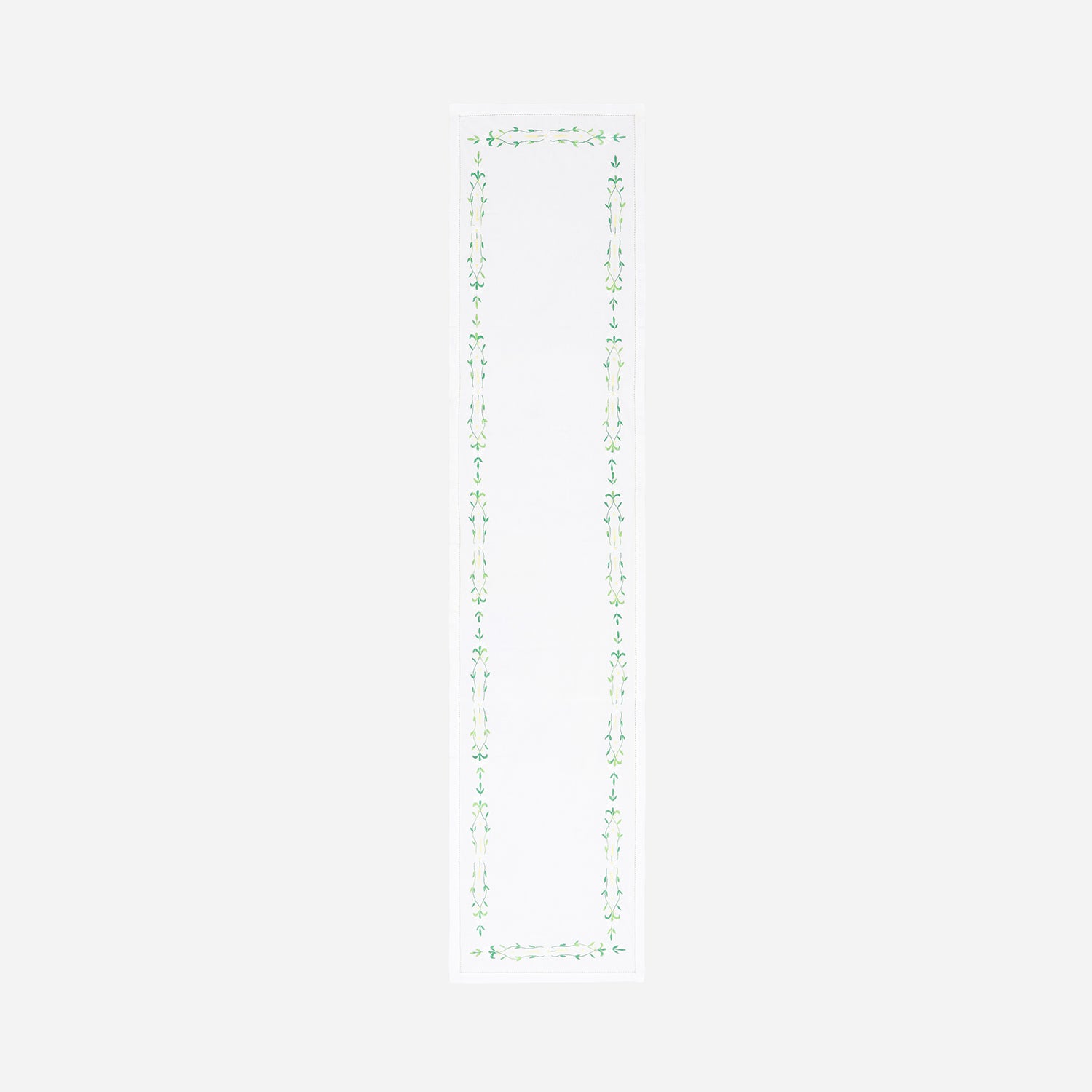 Full-length embroidered table runner featuring green floral vine motifs on a white cotton base displayed on a plain background