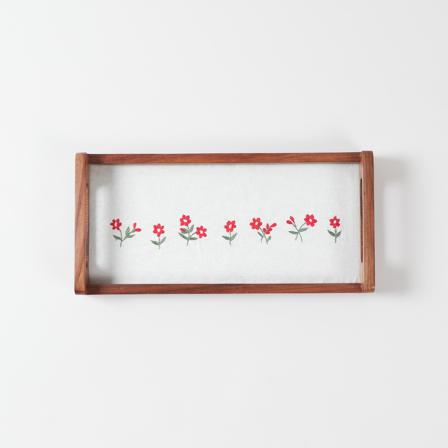 Rectangular sheesham wood serving tray featuring white cotton fabric with pink flower embroidery and green leaf detailing under a glass top