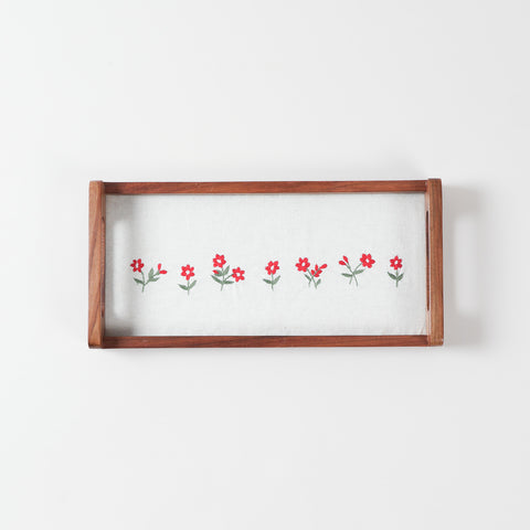 Rectangular sheesham wood serving tray featuring white cotton fabric with pink flower embroidery and green leaf detailing under a glass top
