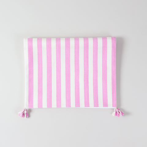 Folded cotton table runner showcasing white and pink woven stripes, handcrafted texture, and decorative tassels