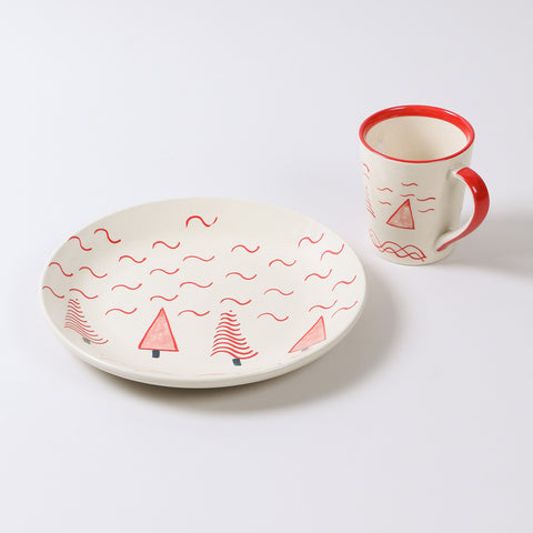 Hand-painted ceramic breakfast set with a white and red Christmas tree design including one 10-inch plate and one ceramic mug on a plain background
