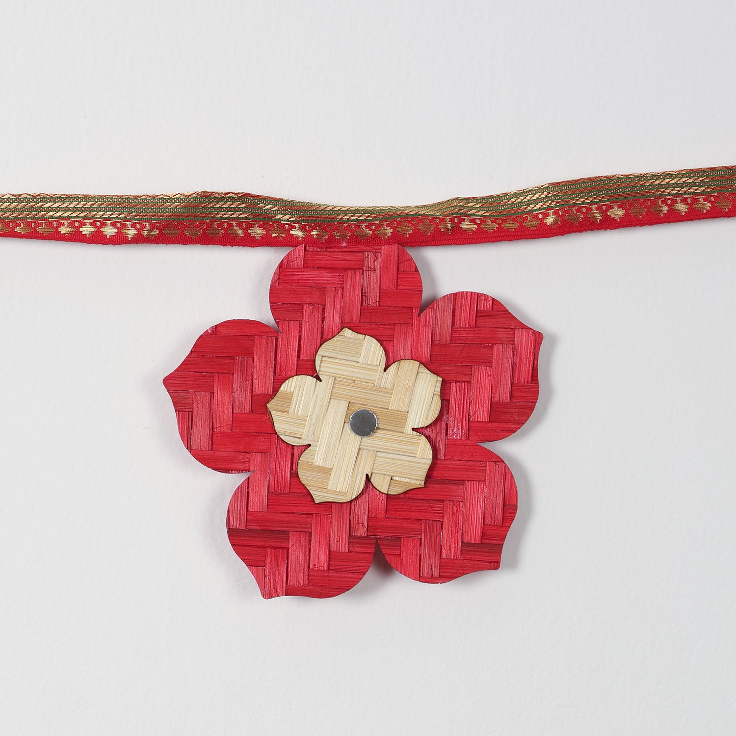 Close-up of colourful geometric flowers on a woven bamboo toran