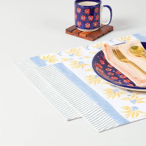 Yellow and blue floral block printed placemats styled with dinner plate and gold cutlery for elegant dining table decor