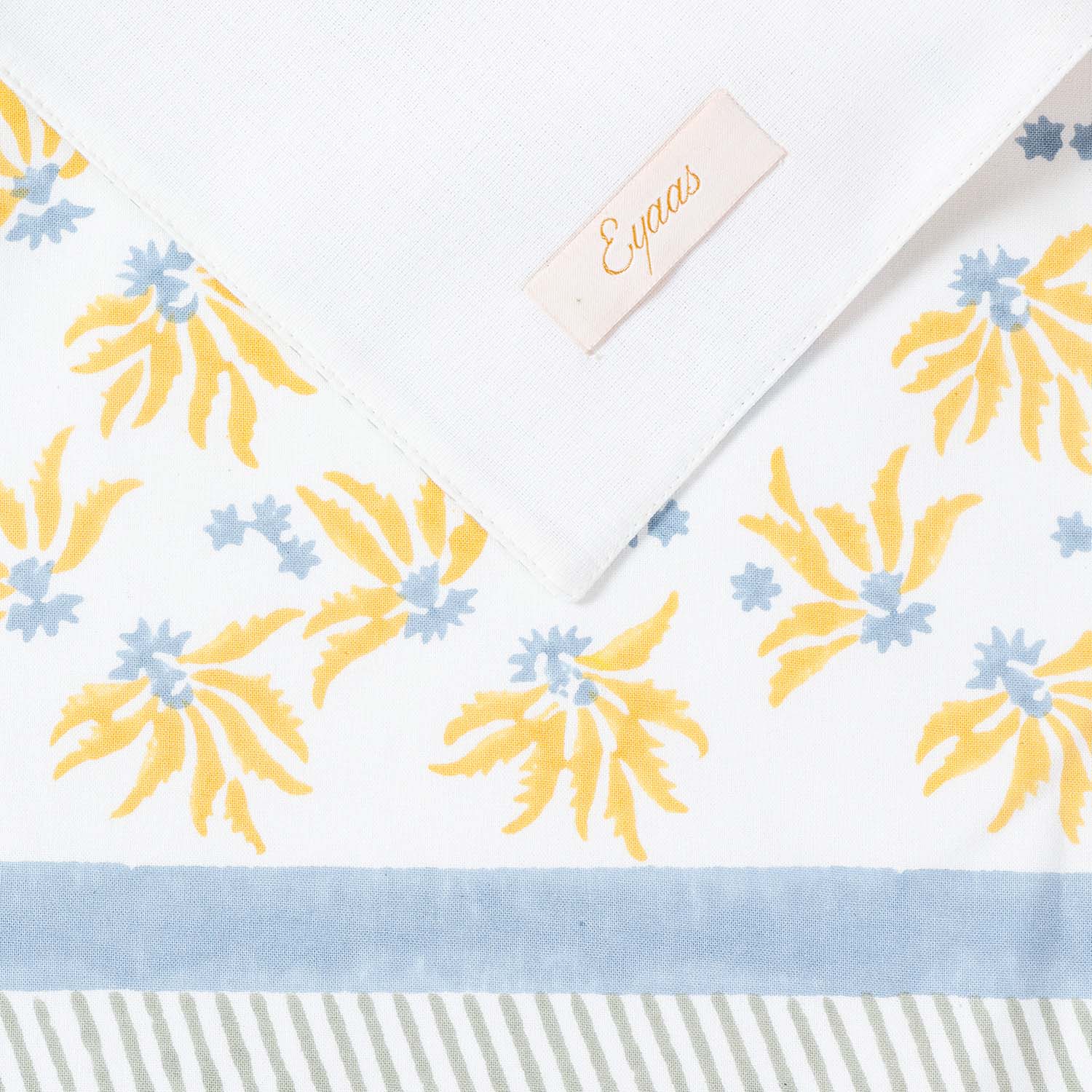Hand block printed cotton placemat showing front and reverse sides with Eyaas brand label detail