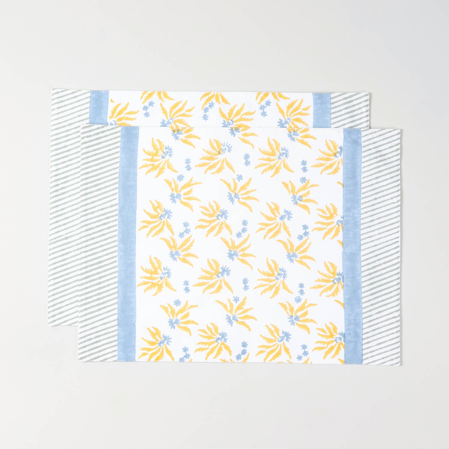 Pack of two floral block printed cotton placemats in yellow and blue for everyday table settings