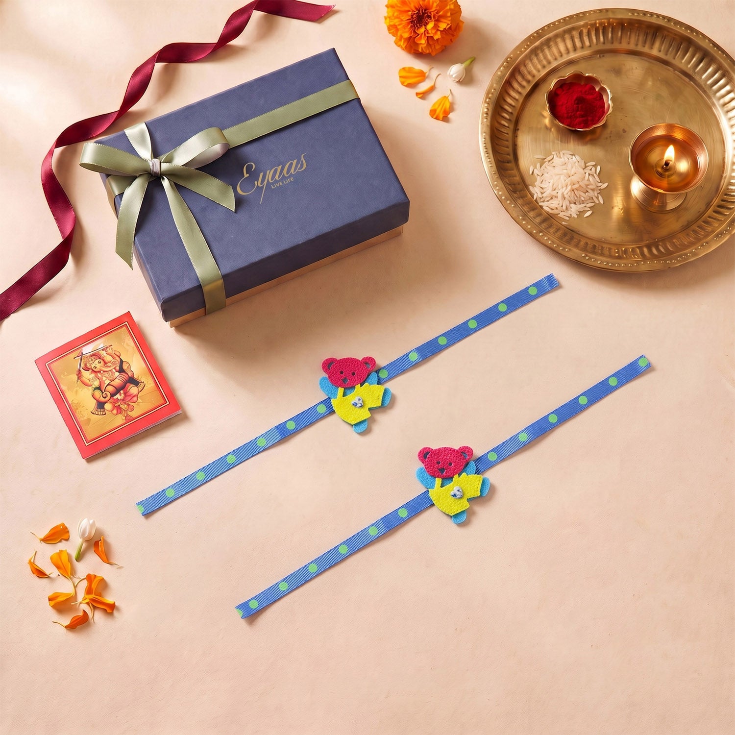Handmade Blue & Yellow Teddy Bear Felt Kids Rakhi, beautifully presented in a festive gift box with blue satin ribbon, ready for Raksha Bandhan gifting.
