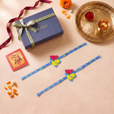 Handmade Blue & Yellow Teddy Bear Felt Kids Rakhi, beautifully presented in a festive gift box with blue satin ribbon, ready for Raksha Bandhan gifting.