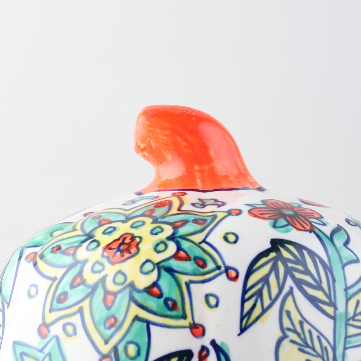 Close-up of yellow floral hand-painted artwork on a ceramic pumpkin candle holder crafted in Khurja
