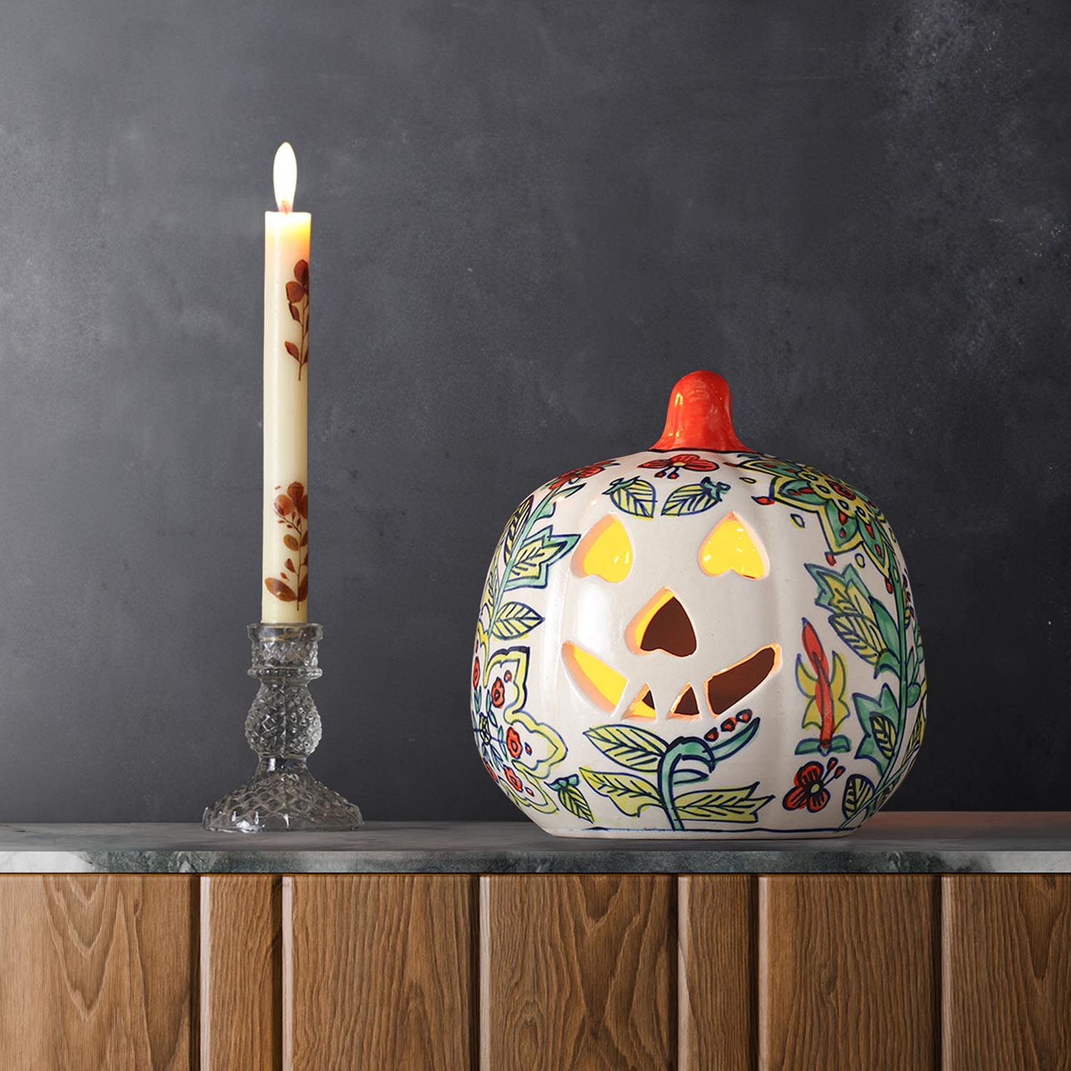 Yellow floral ceramic pumpkin tea light holder styled with candlelight in a festive home decor setting