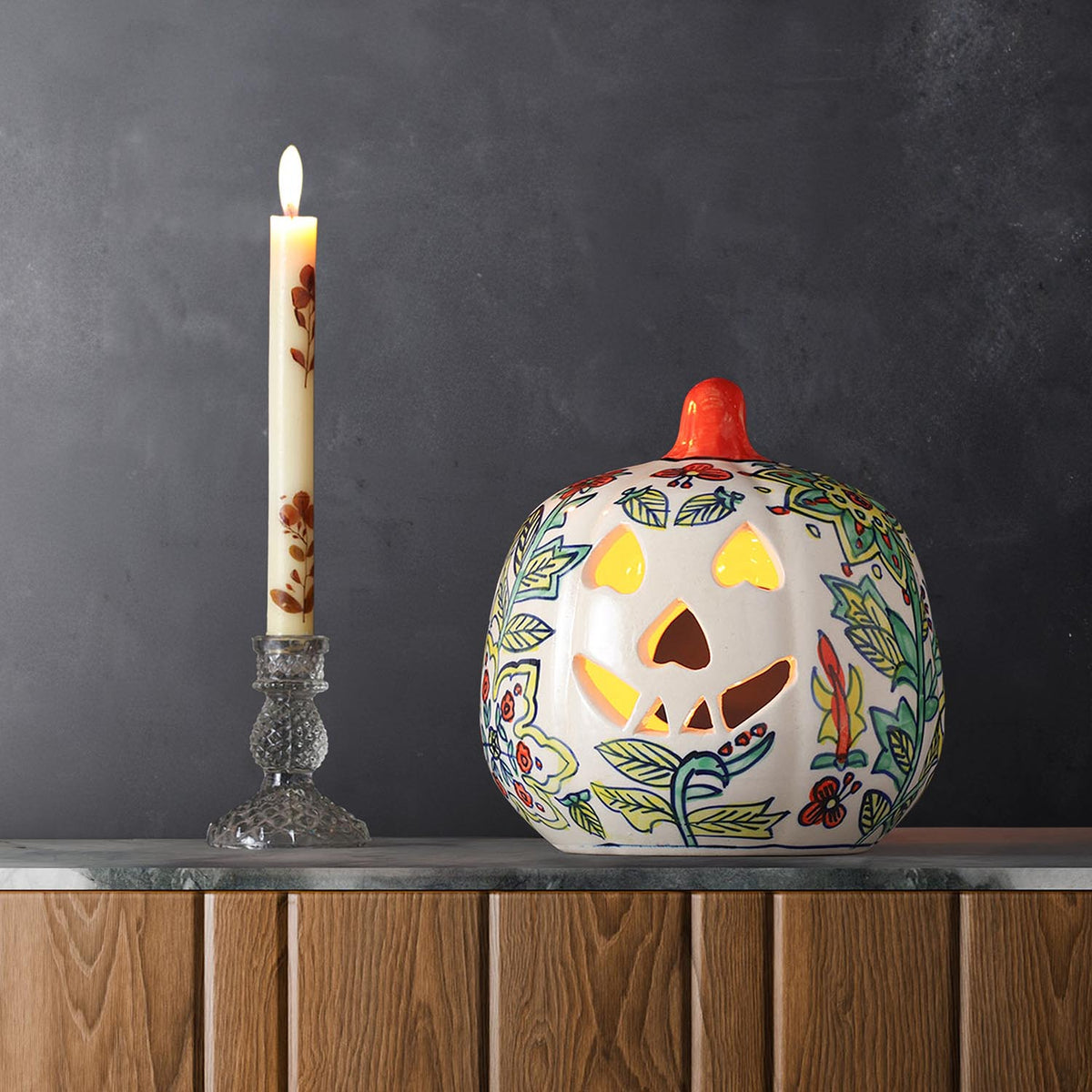 Yellow floral ceramic pumpkin tea light holder styled with candlelight in a festive home decor setting