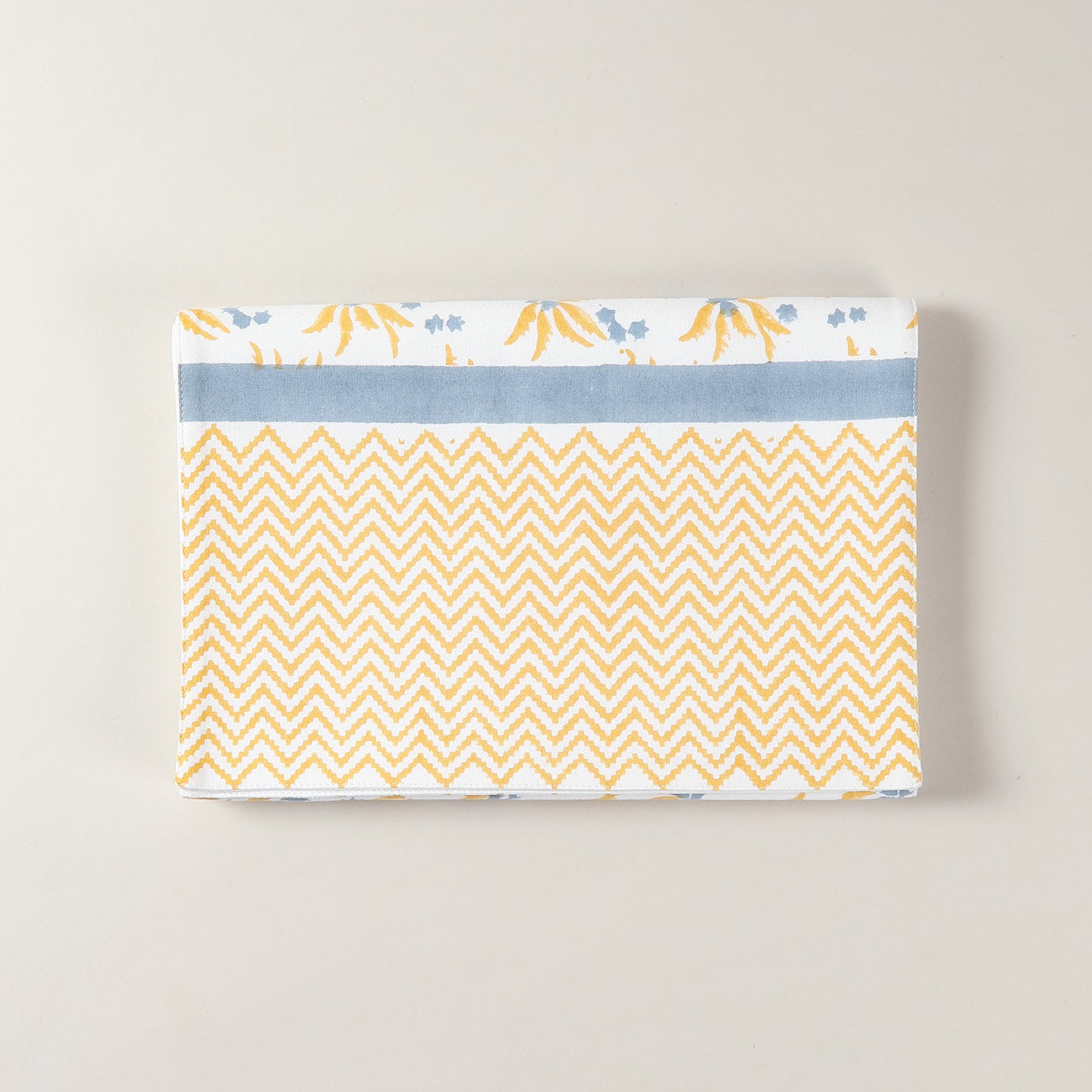 Folded cotton table runner featuring yellow and blue floral motifs with handcrafted block printed design