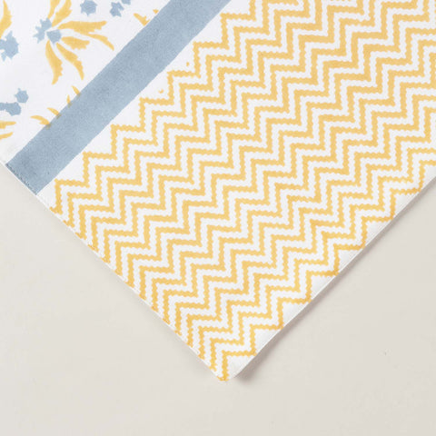 Close-up of yellow floral pattern and blue border accents on hand block printed table runner