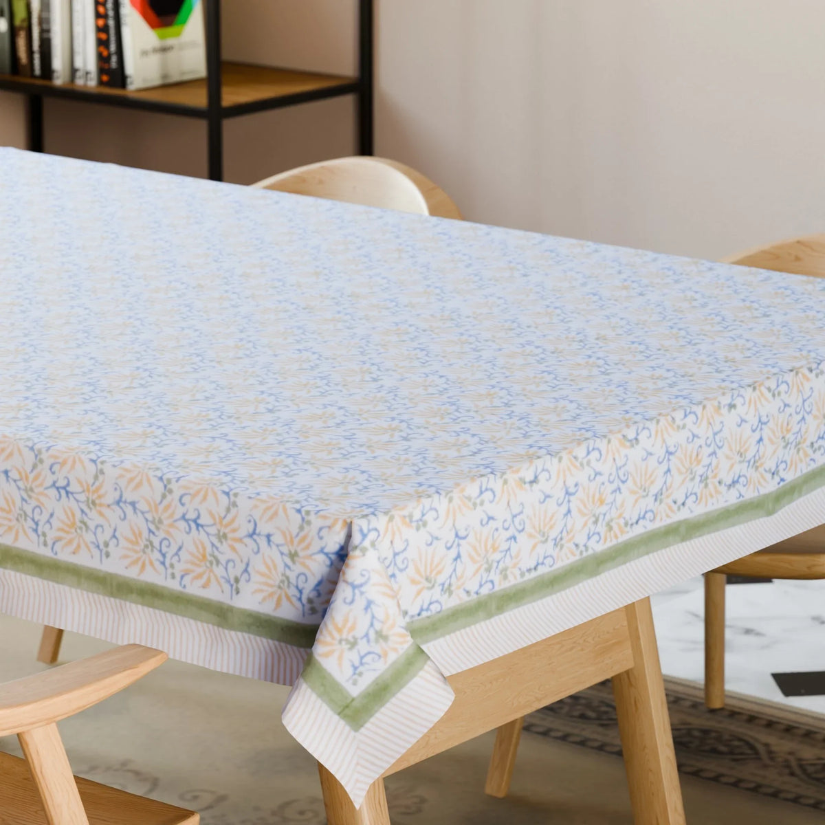 Yellow lily hand block printed cotton tablecloth styled on a dining table with coordinated tableware and floral decor