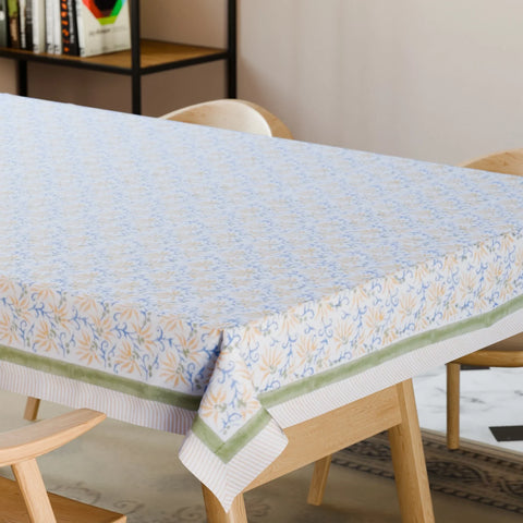 Yellow lily hand block printed cotton tablecloth styled on a dining table with coordinated tableware and floral decor