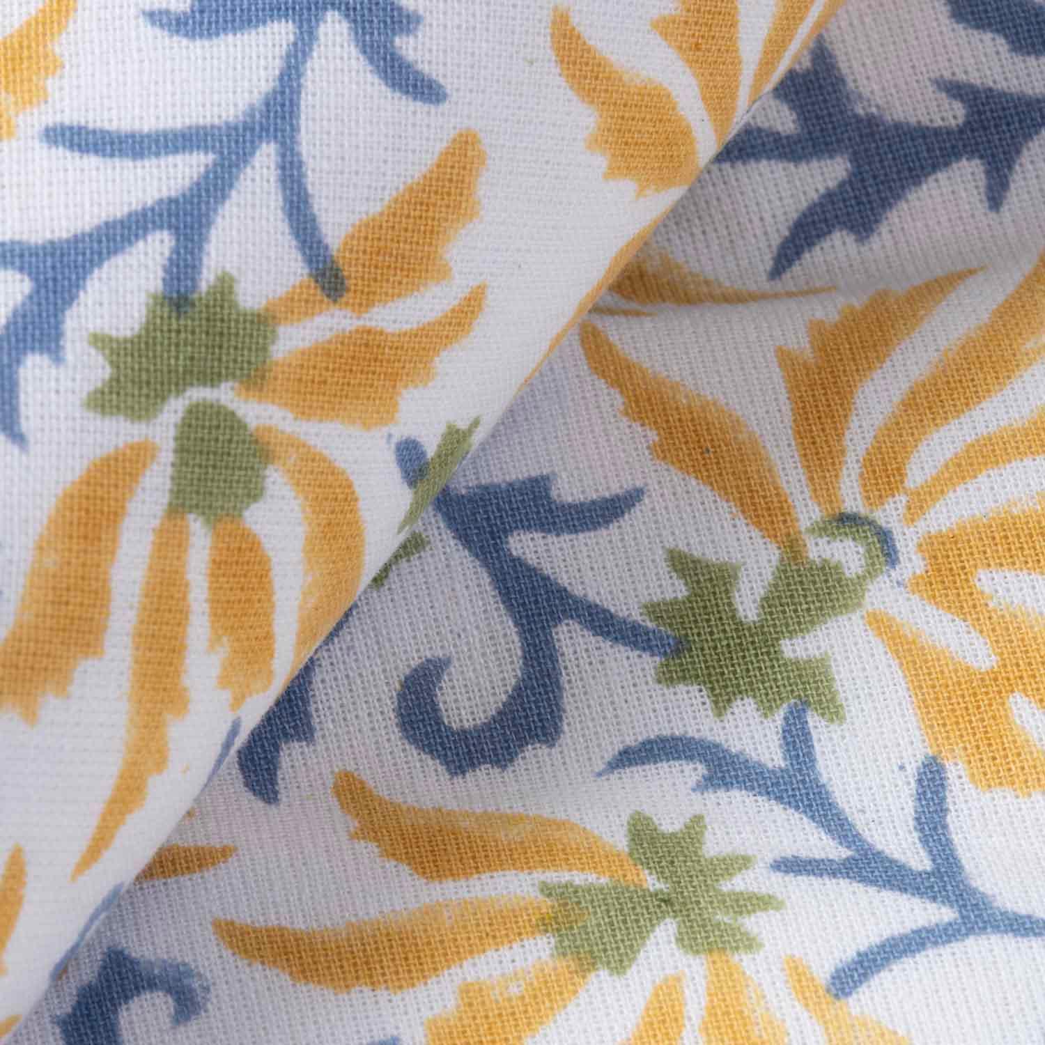 Close-up of yellow lily floral motifs and blue vine block printing on a handcrafted cotton table cloth