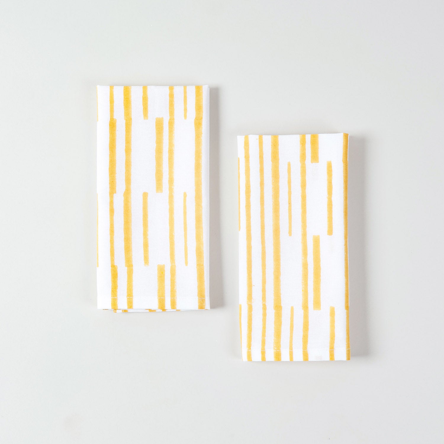 White and yellow cotton table napkins with handcrafted stripe pattern for cheerful table settings