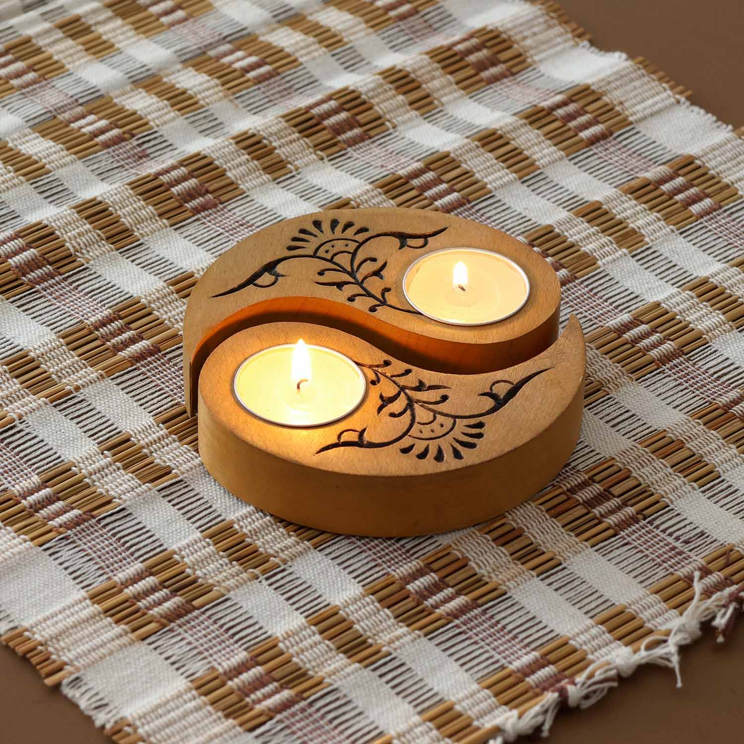 Hand carved wooden Ying Yang floral T-light holders set of 2 in yellow, displayed with lit tea lights on a woven mat, ideal for handmade decor and Diwali decor