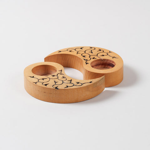 Angled view of hand carved wooden T-light holders in yellow, featuring leaf carvings and a Ying Yang shape, perfect for decorative candle holder displays